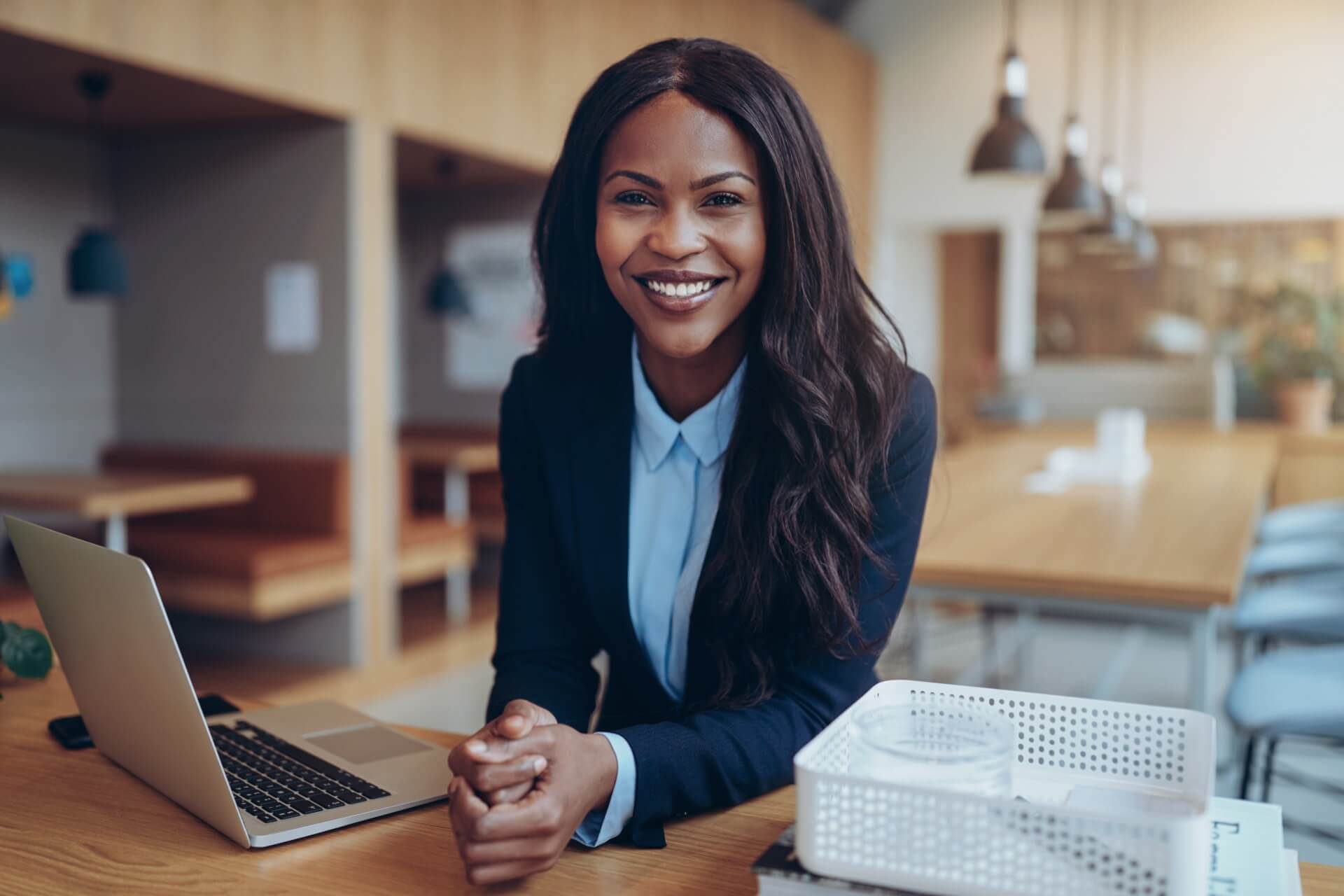 Image Of A Woman In Business Attire Seated At A Desk With Her Laptop Opened