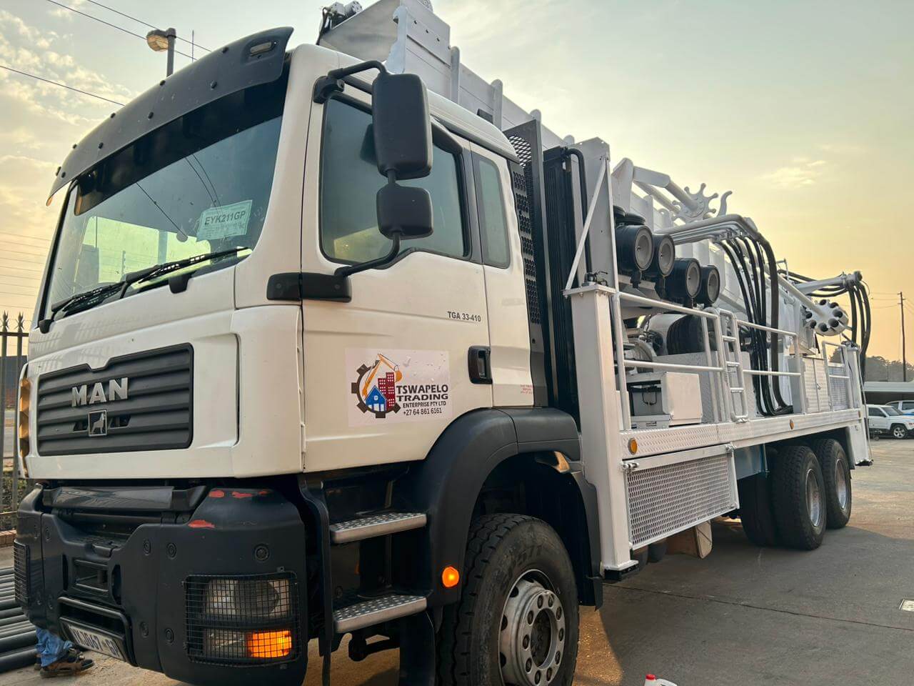 A White Man Drill Rig Truck Parked Outdoors At Sunset, Showcasing The Vehicle And Mounted Drilling Equipment.