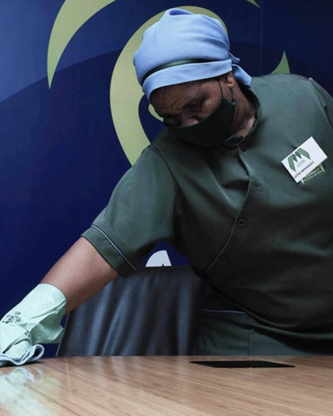 Cleaner Sanitizing A Boardroom Table.