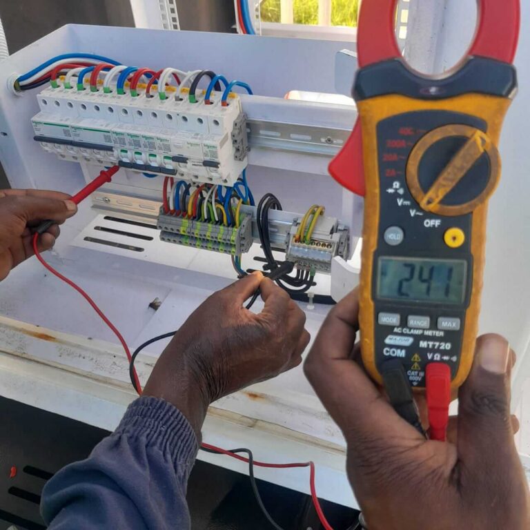 Technician Using Multimeter To Test Electrical Connections On Panel. (1)